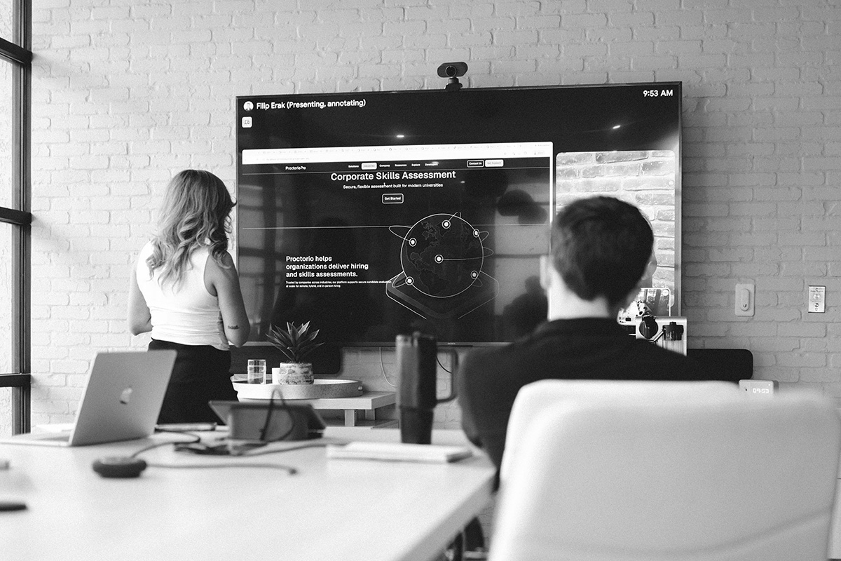 A Proctorio employee presenting to teammates in a conference room