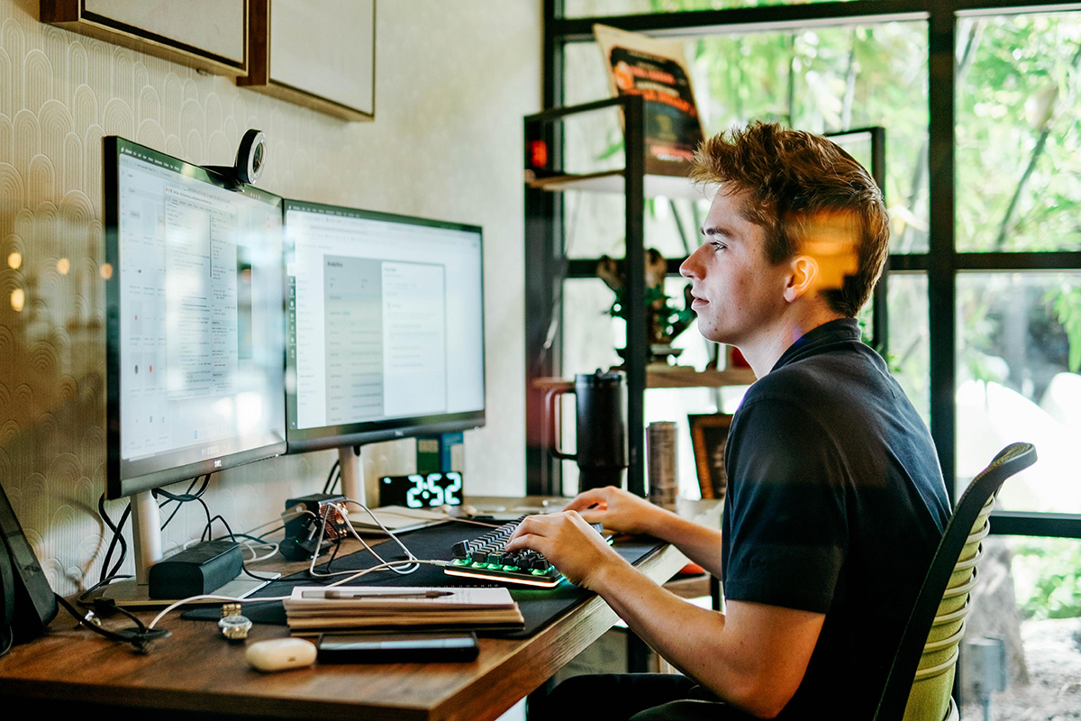 A Proctorio engineer working at a dual-monitor desk