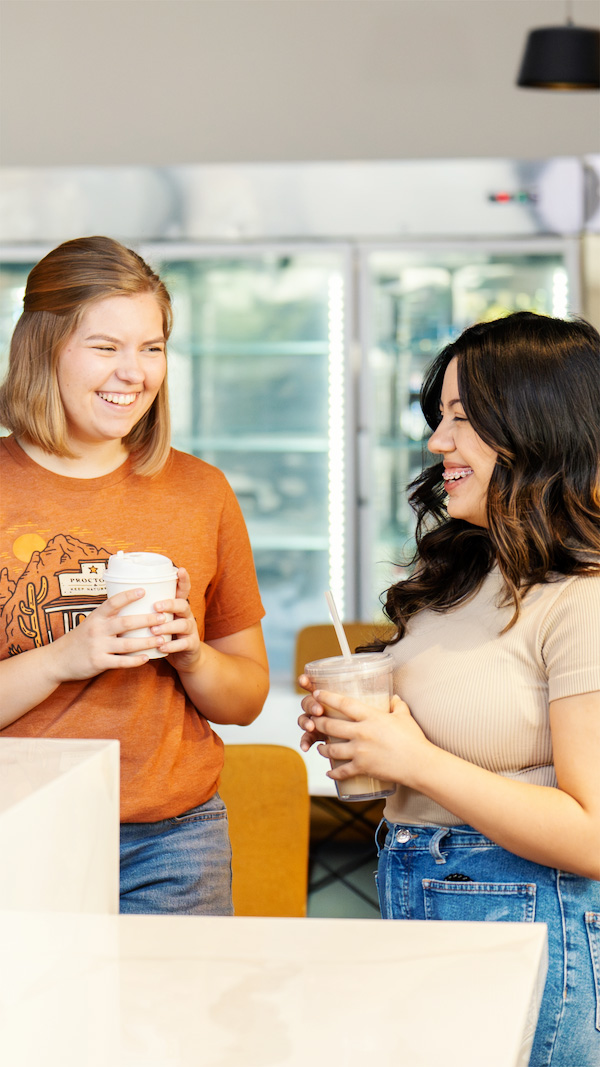 Two Proctorio employees talking over coffee in the office kitchen
