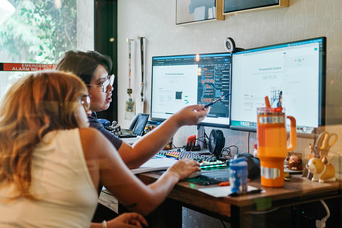 Two Proctorio employees reviewing work on a monitor together