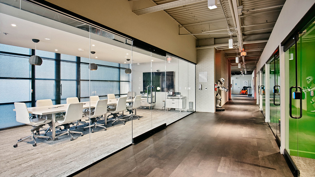 Glass-walled meeting rooms along a Proctorio office hallway